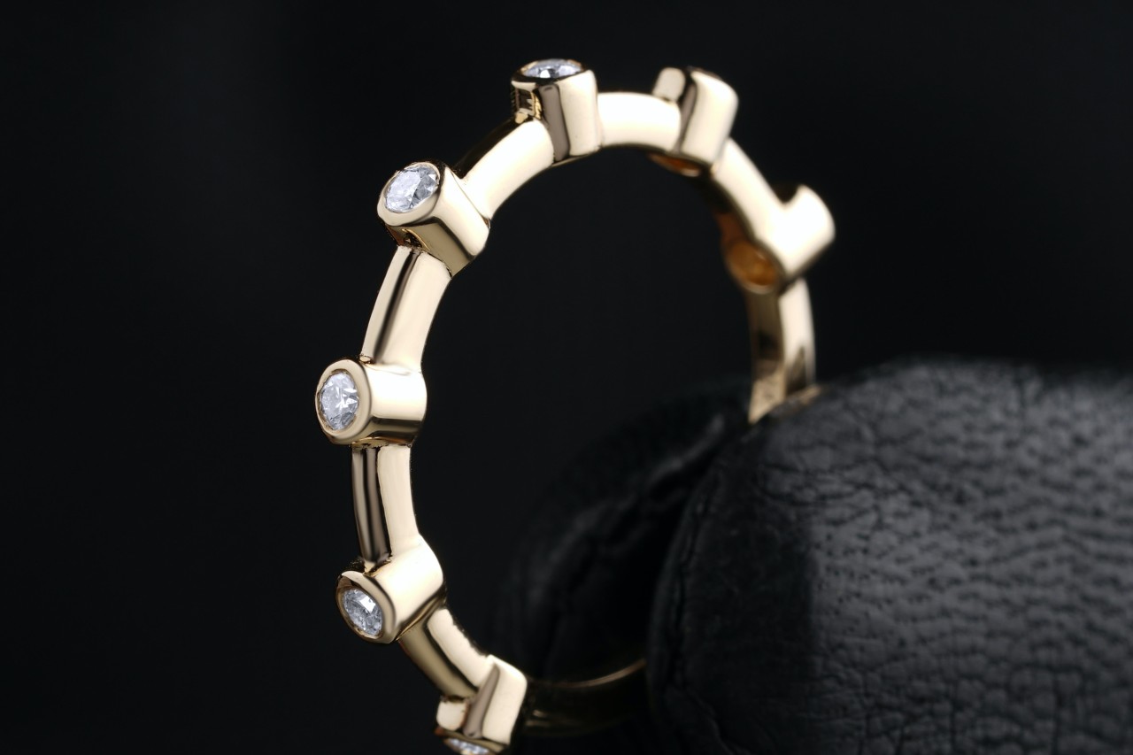 a diamond and gold wedding band on a black background